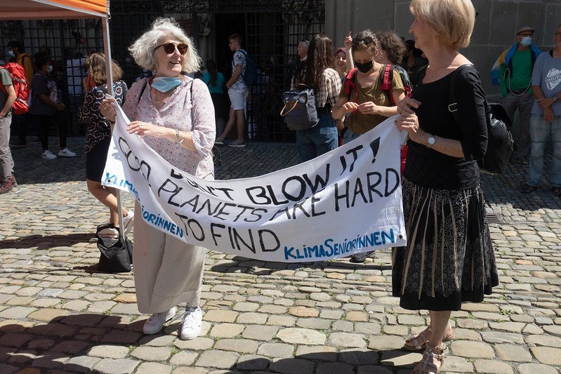 Ladies holding sign saying "don't blow it, good planets are hard to find"