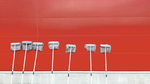 seven white push mops on wall