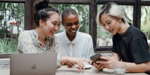 Three young adults laugh as they look at their phones Digital self-determination